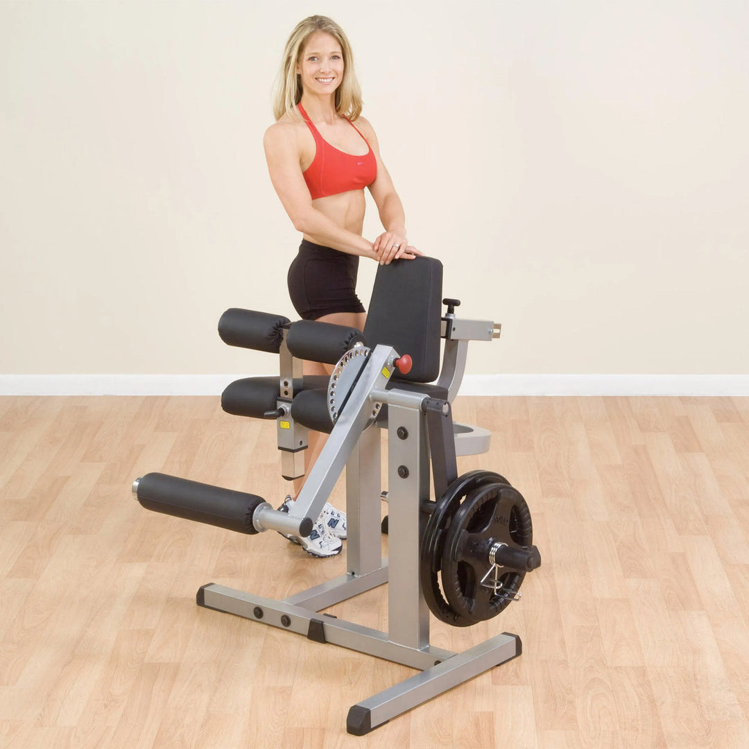 A woman showcasing the Body-Solid Leg Extension and Curl Machine GCEC340