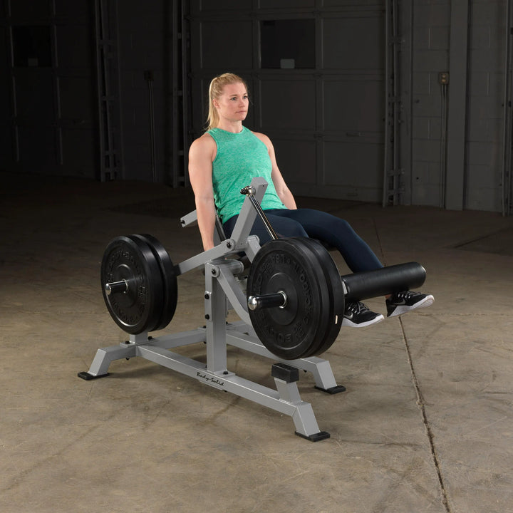 A woman training on the Body-Solid Leg Extension Machine LVLE