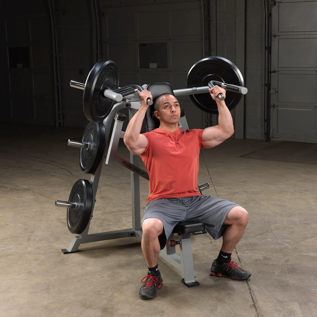 A man training on the Body-Solid Seated Shoulder Press Machine LVSP