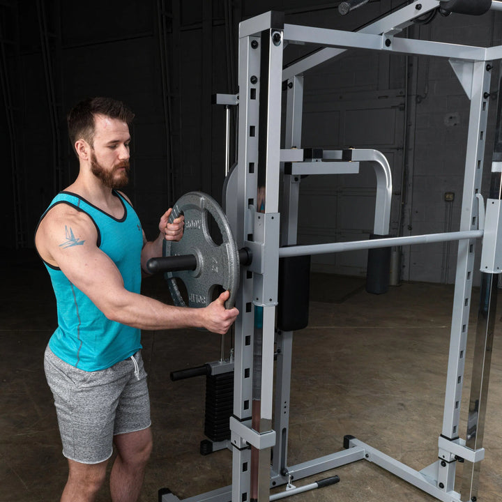 A man preparing to train on the Body-Solid Powerline Home Smith Machine PSM1442XS