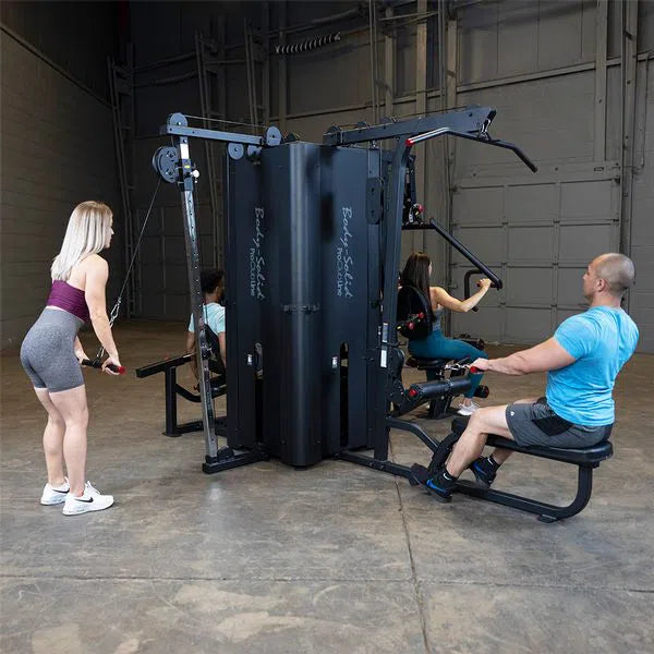 A group of four all training on each station of the Body-Solid Commercial Universal Weight Machine S1000