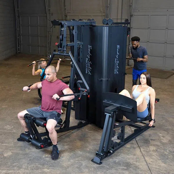 Four people training at the same time on the Body-Solid Pro Clubline S1000, one at the press arm, one at the lat pulldown, one at the cable column and one on the leg press