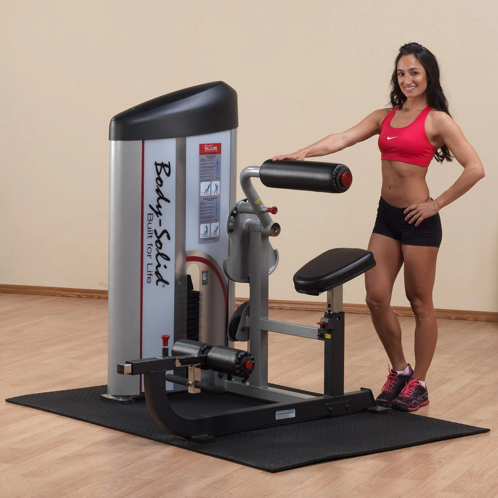A woman showcasing the Body-Solid Ab Crunch and Back Extension Machine S2ABB