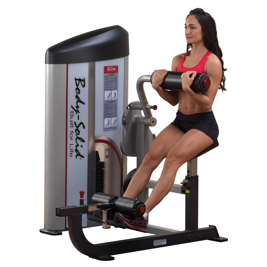 A woman training on the Body-Solid Ab Crunch and Back Extension Machine S2ABB