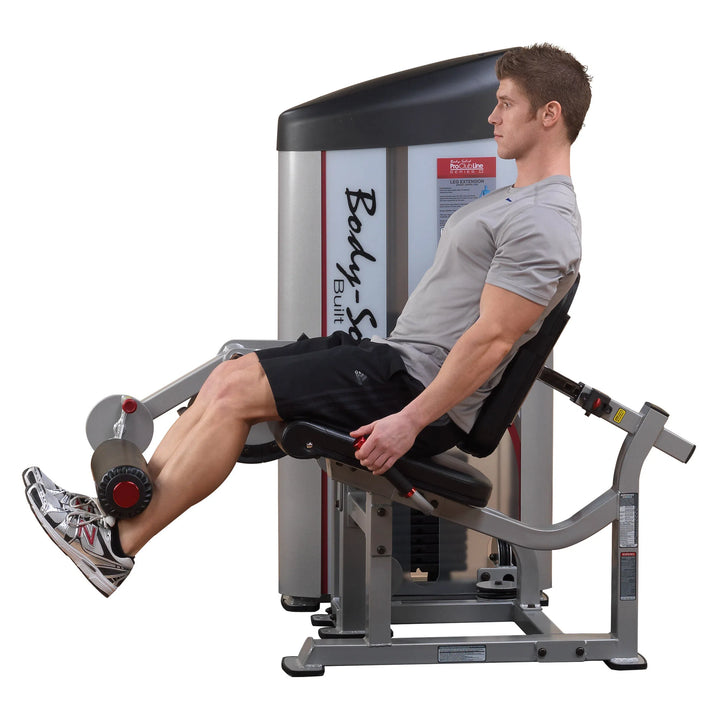 A man training on the Body-Solid Seated Leg Extension Machine S2LEX