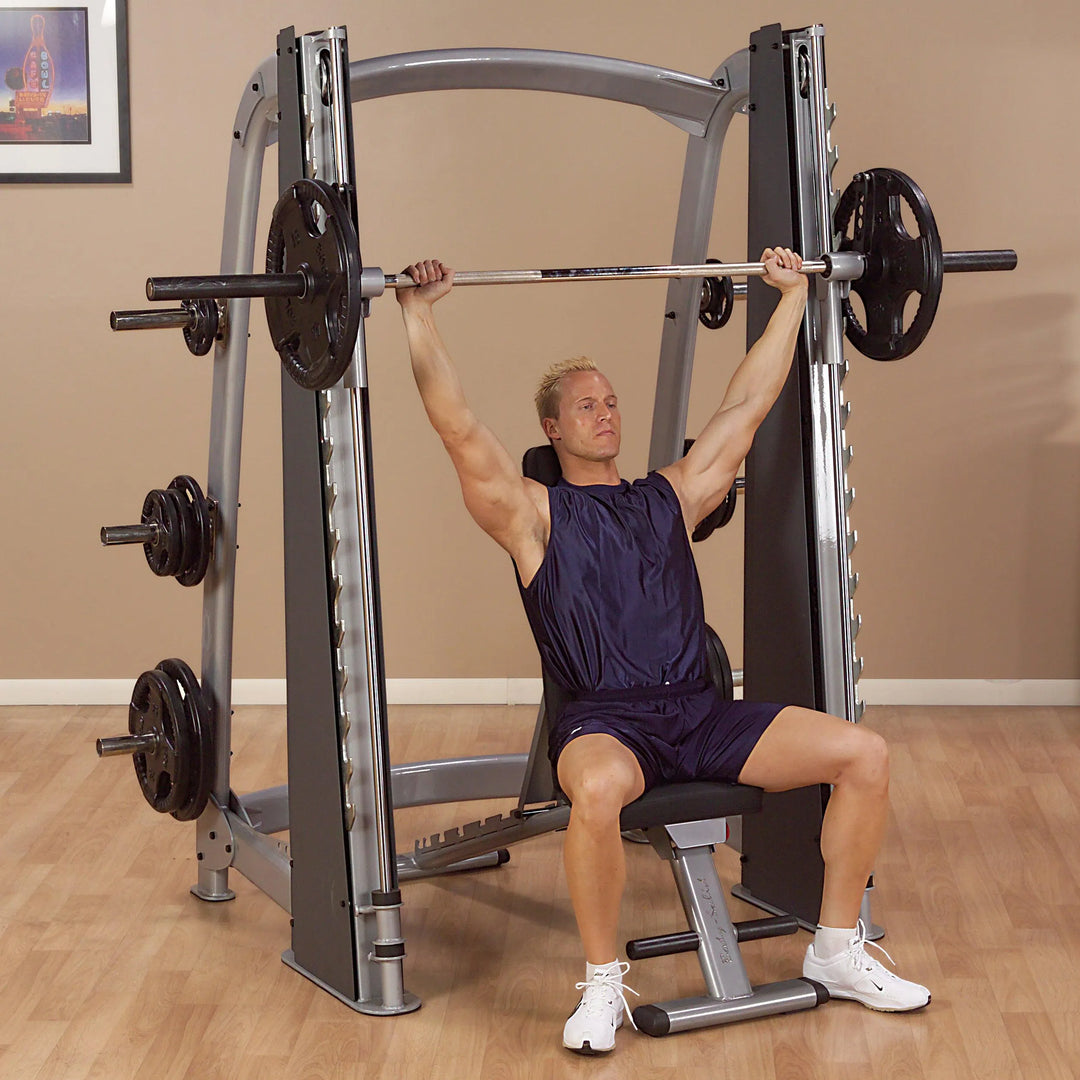 A man doing shoulder presses on the Body-Solid Commercial Smith Machine SCB1000