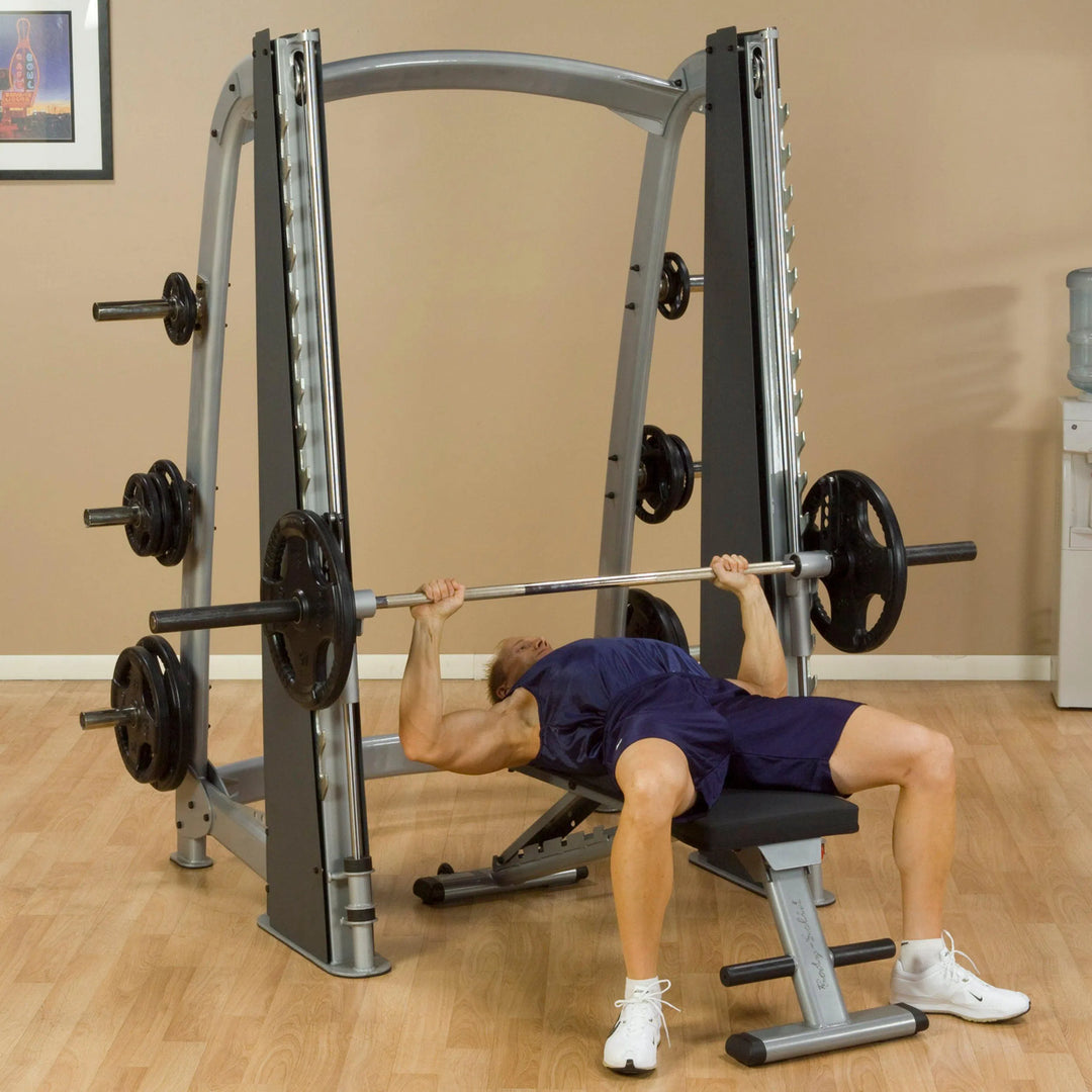 A man doing flat bench presses on the Body-Solid Commercial Smith Machine SCB1000