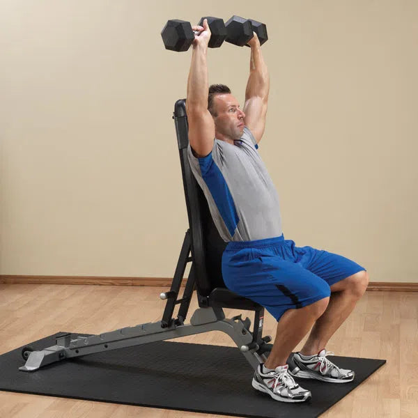 A man doing dumbbell shoulder presses on the Body-Solid FID Bench SFID325