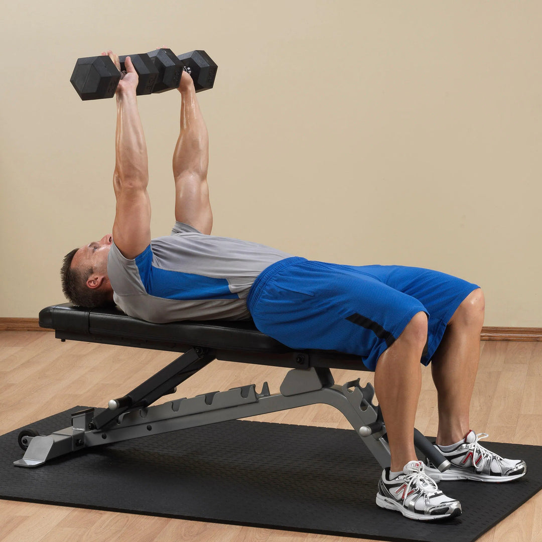 A man doing flat dumbbell presses on the Body-Solid FID Bench SFID325