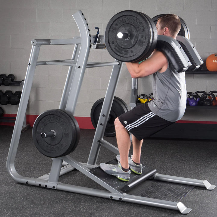 A man doing elevated squats on the Body-Solid Leverage Squat Machine SLS500