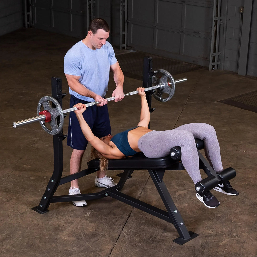 A man spotting a woman doing decline bench presses on the Body-Solid Commercial Olympic Decline Bench SODB250