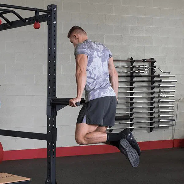 A man doing dips on the dip handles attachment for the Body-Solid Commercial Power Rack SPR1000