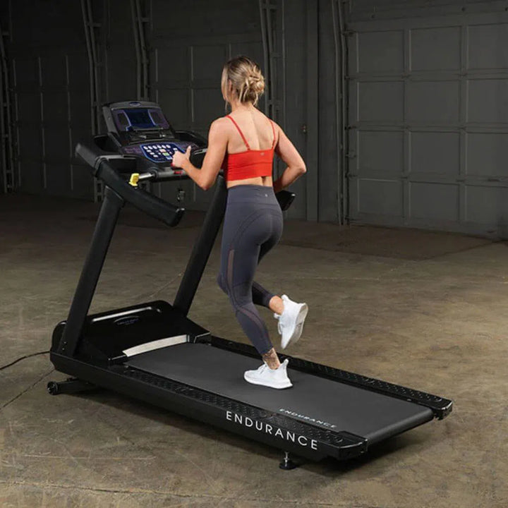 young woman running on Body-Solid Endurance Commercial Grade Treadmill T150