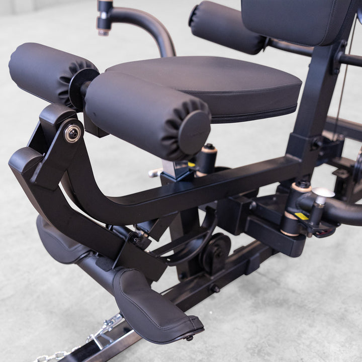 Close up of the Body-Solid G6B leg developer showing the DuraFirm roller pads, seat and ankle strap