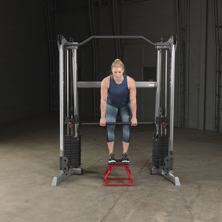 Body-Solid GDCCBAR dual press bar clipped onto both cables of a functional trainer
