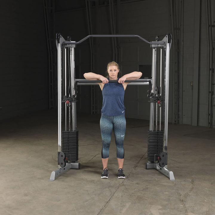 Body-Solid GDCCBAR dual press bar in use for a shoulder press