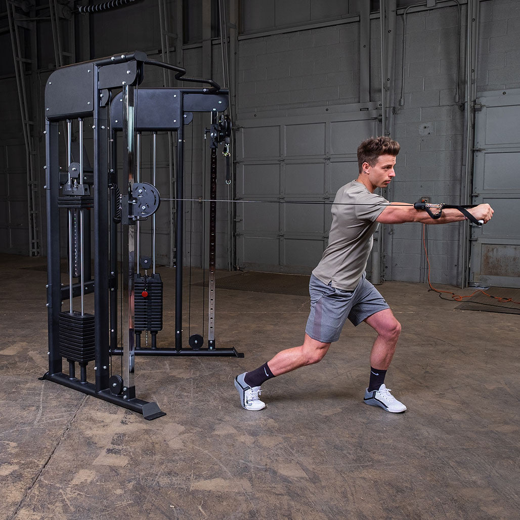 Standing cable punch and rotation exercise on the Body-Solid GFT100, showing the swivel range of the adjustable pulley