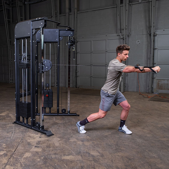 Standing cable punch and rotation exercise on the Body-Solid GFT100, showing the swivel range of the adjustable pulley
