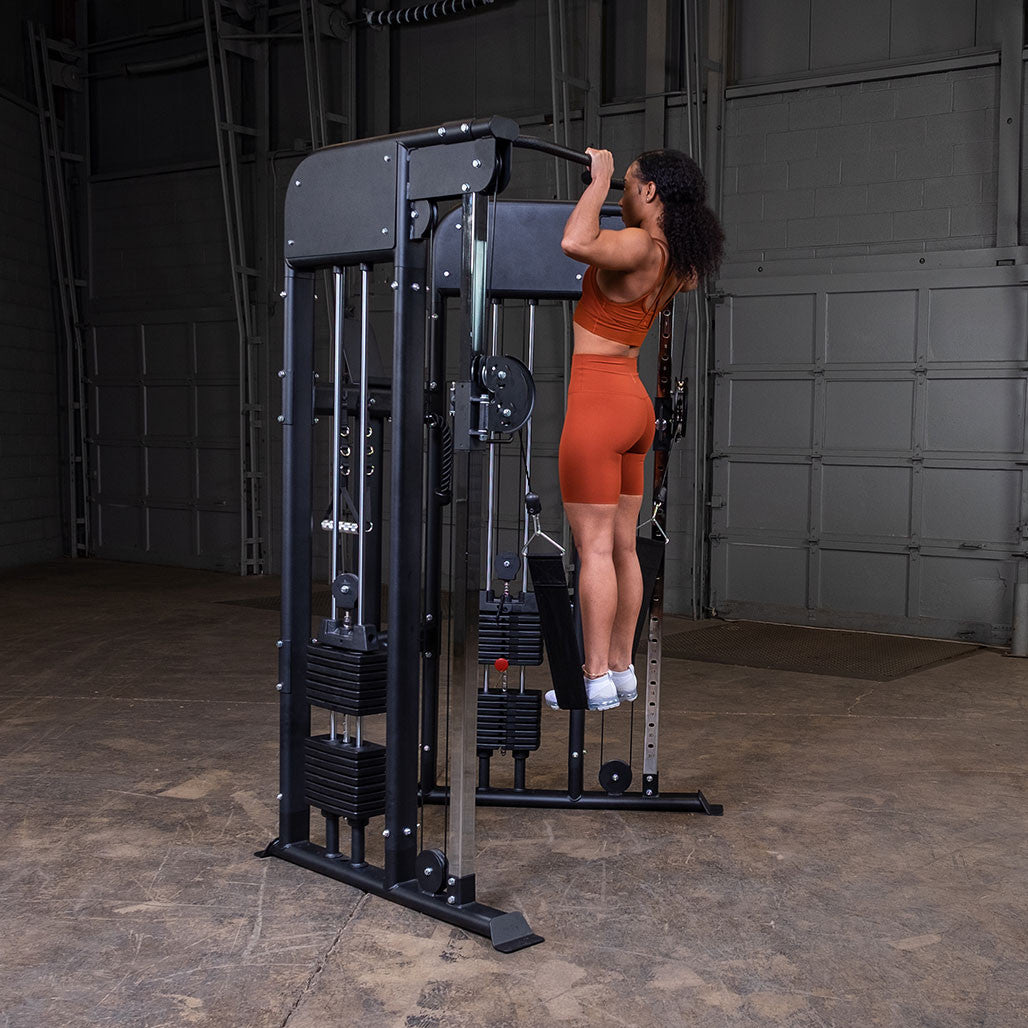 Man doing pull-ups on the integrated chinning bar of the Body-Solid GFT100 functional trainer