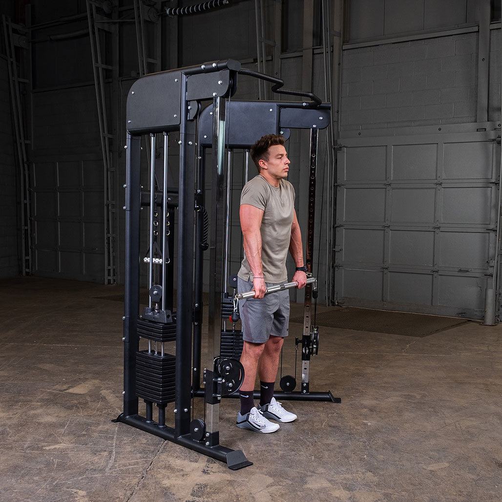 Standing cable shrugs using both stirrup handles on the Body-Solid GFT100, pulleys set low