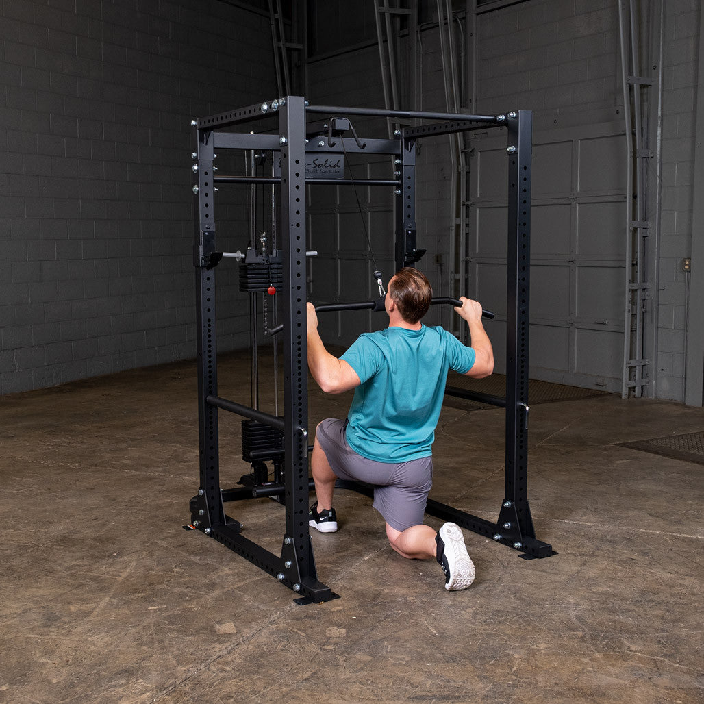 Man kneeling to do a lat pulldown on the GLA400 attachment mounted to a Body-Solid GPR400 power rack
