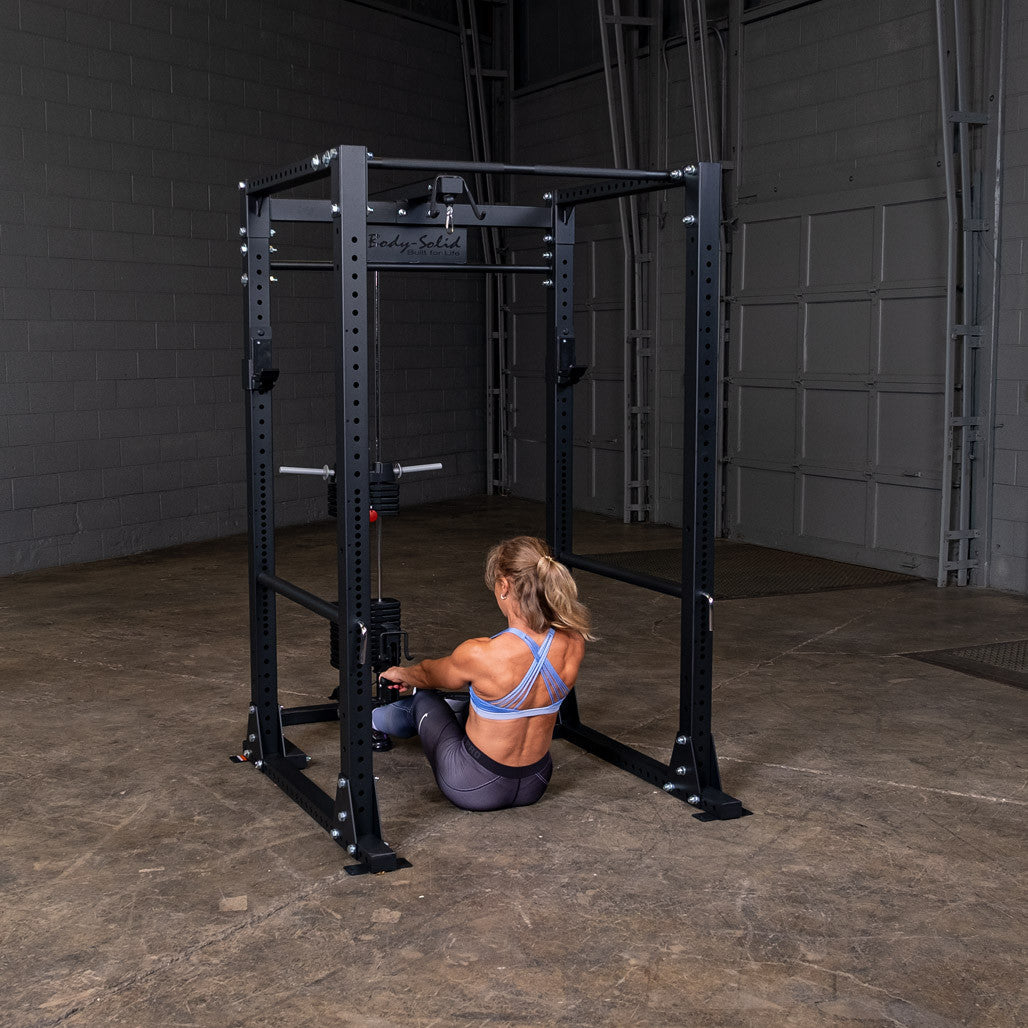 Woman seated on the floor doing a low pulley row on the GLA400 attachment mounted to a Body-Solid GPR400 power rack