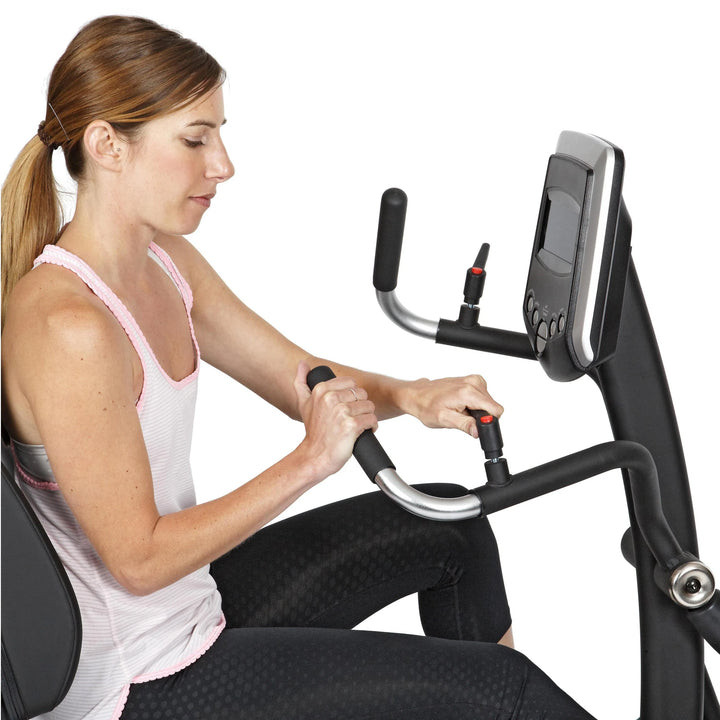 A woman training on the HCI PhysioStep HXT Seated Elliptical HXT-300
