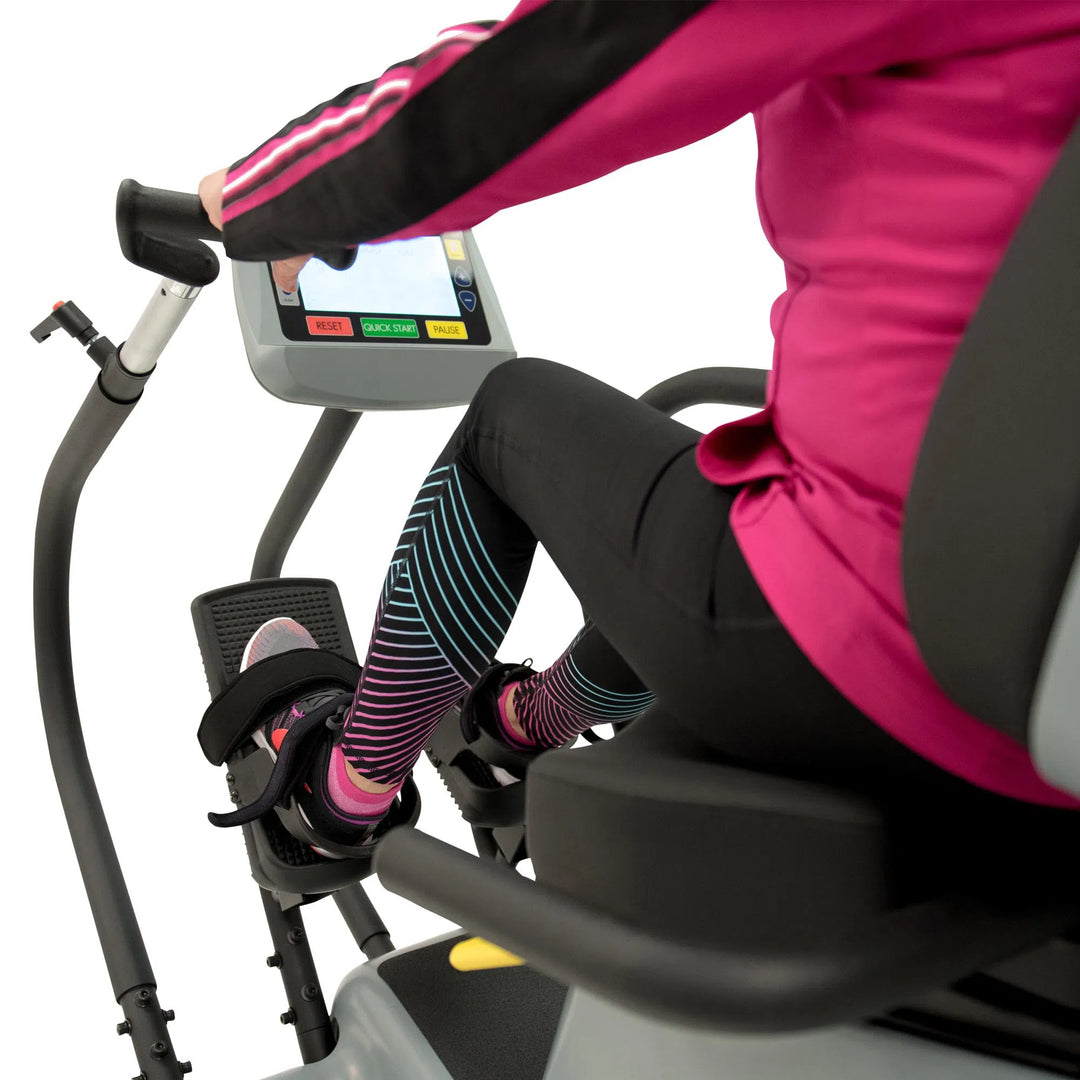 An elderly woman training on the HCI PhysioStep LXT Recumbent Stepper