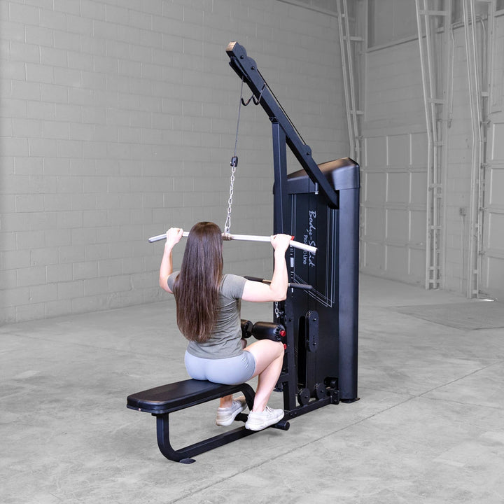 Body-Solid S2LATX seated mid row in use, with a lifter braced against the chest pad pulling the straight low row bar.