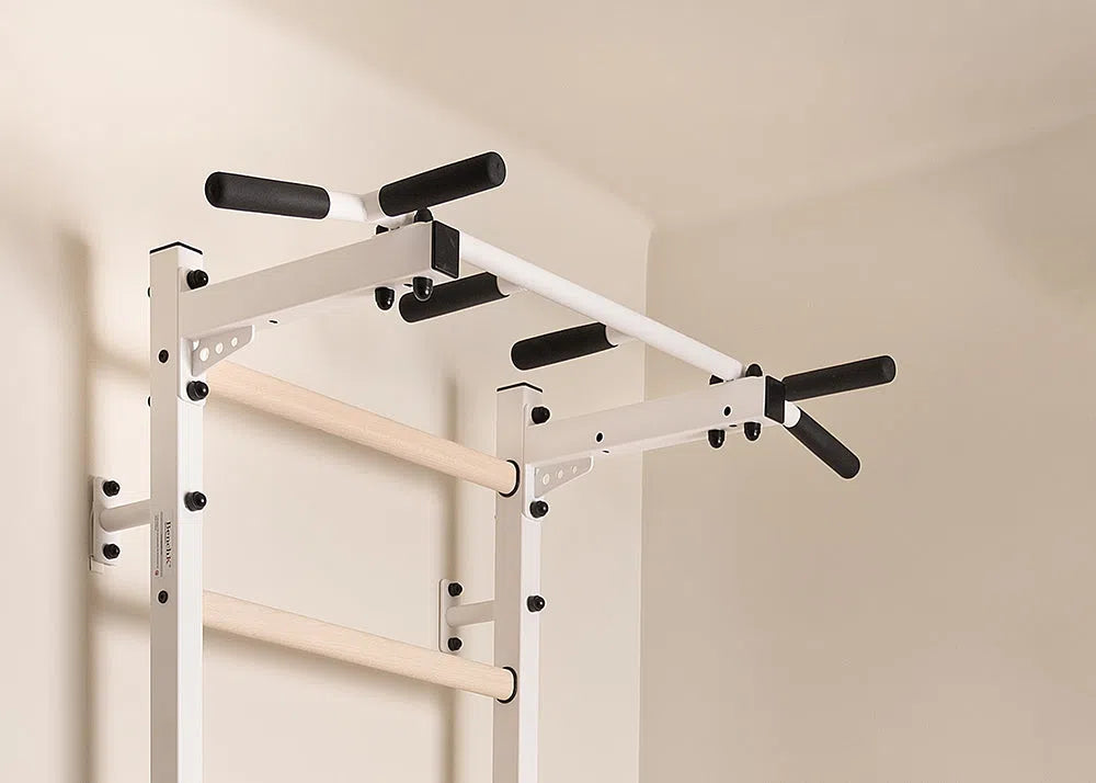 The BenchK Home Swedish Ladder w/ Pull-Up Bar (721) is essential for any home gym. It mounts on a light-colored wall, features multiple grips and two wooden rungs, and integrates seamlessly into your space with its sturdy metal frame and black handles.