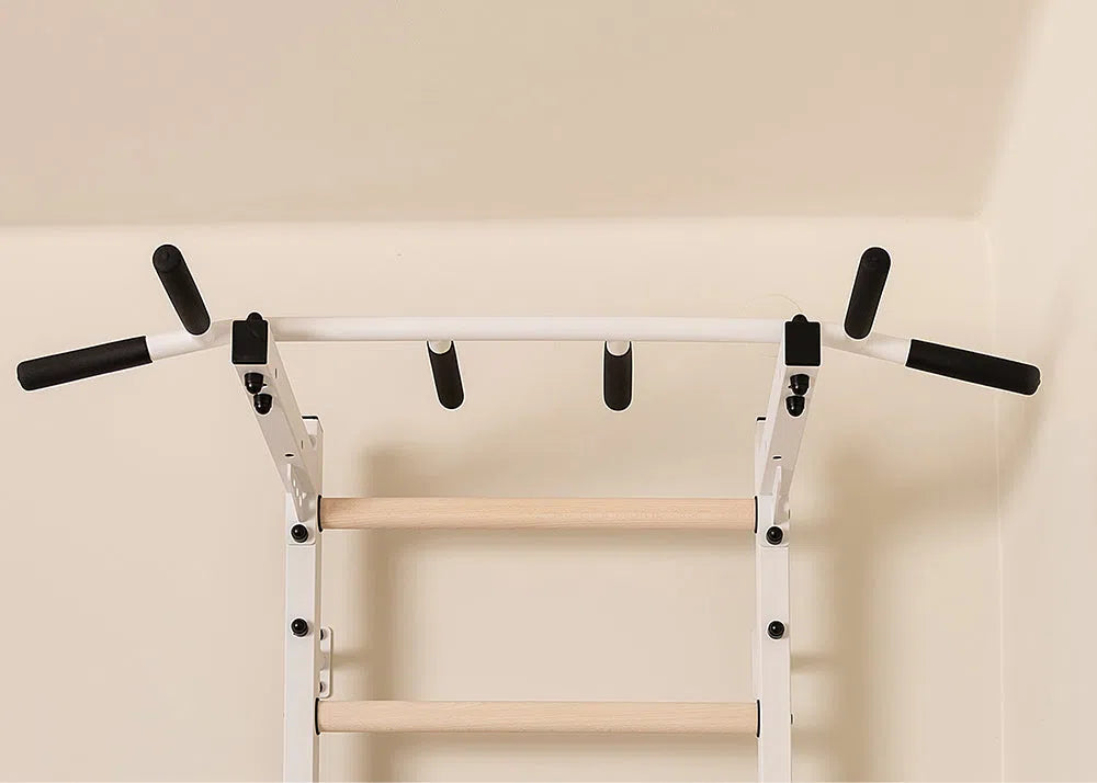 The BenchK Home Swedish Ladder w/ Pull-Up Bar (721) by BenchK is a white, wall-mounted unit with black grips offering multiple grip positions. It integrates functionality and style, perfect for a dedicated home gym fitness area.