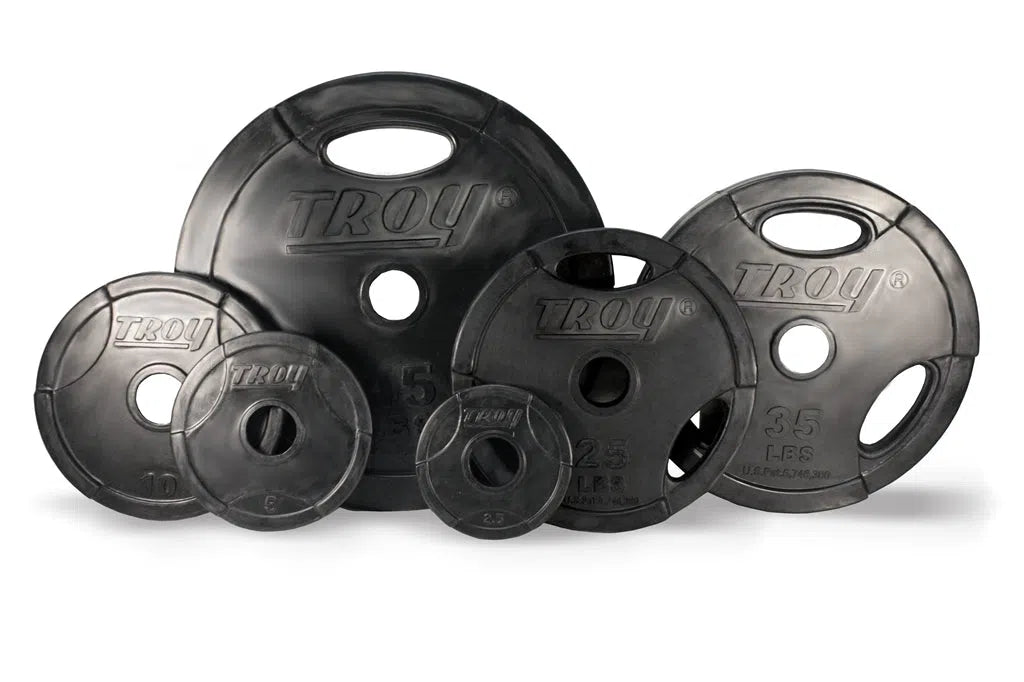 A set of six upright black Troy Rubber Olympic Weight Plates features a Tri-Grip Design with cutout handles, displaying the TROY Barbell brand. They ensure weight accuracy, ranging from 2.5 lbs to 45 lbs.