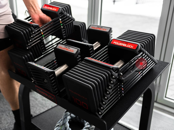 Returning a PowerBlock Commercial Pro 100 dumbbell to the Pro Rack stand after a set