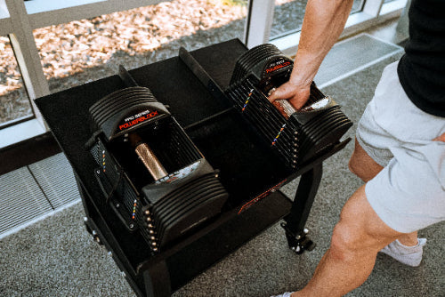 PowerBlock Commercial Pro 50 adjustable dumbbells, part 505-00121-01, in a commercial gym setting