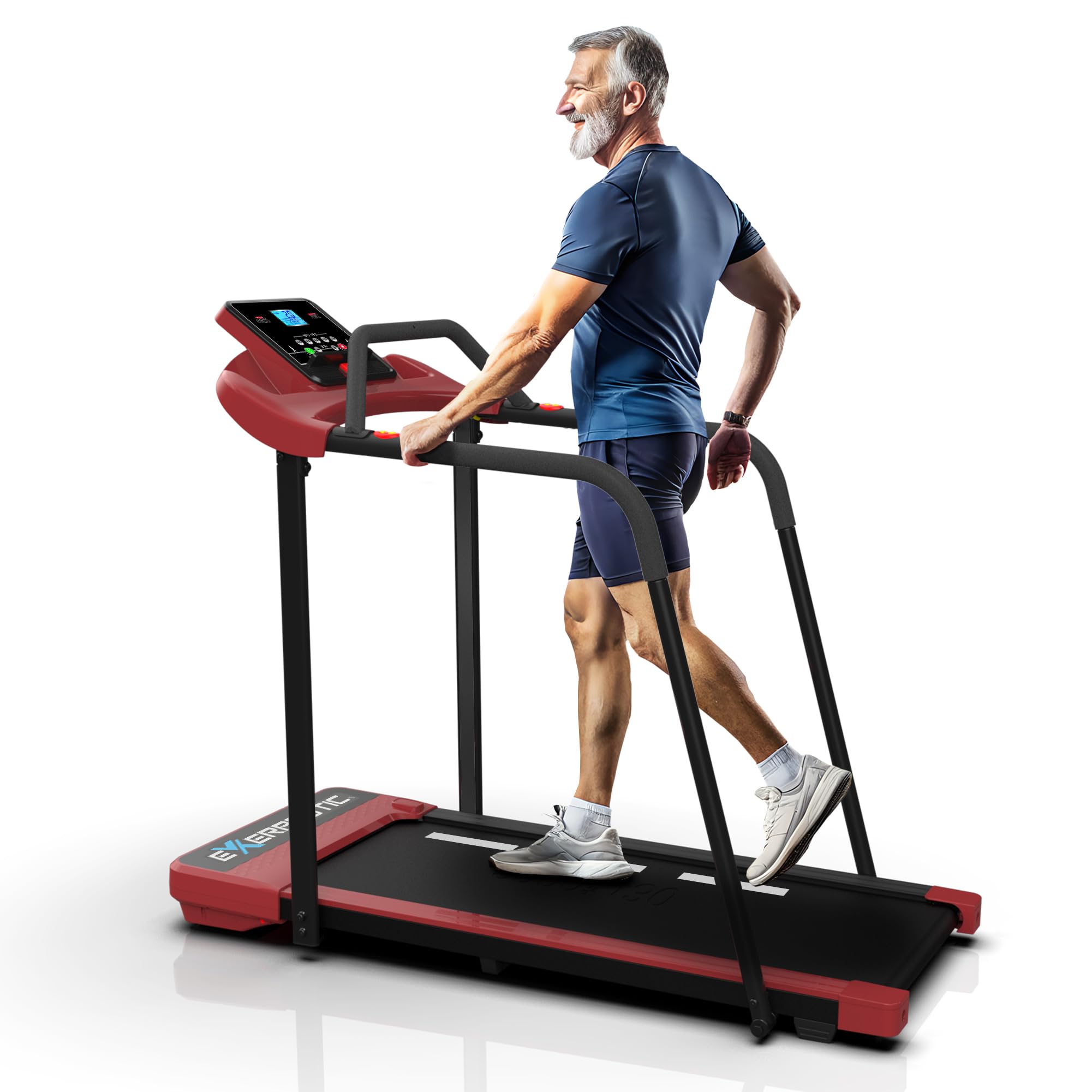 An older man with gray hair and a beard, wearing a blue shirt and shorts, walks on a red and black treadmill, smiling and holding the handrails.
