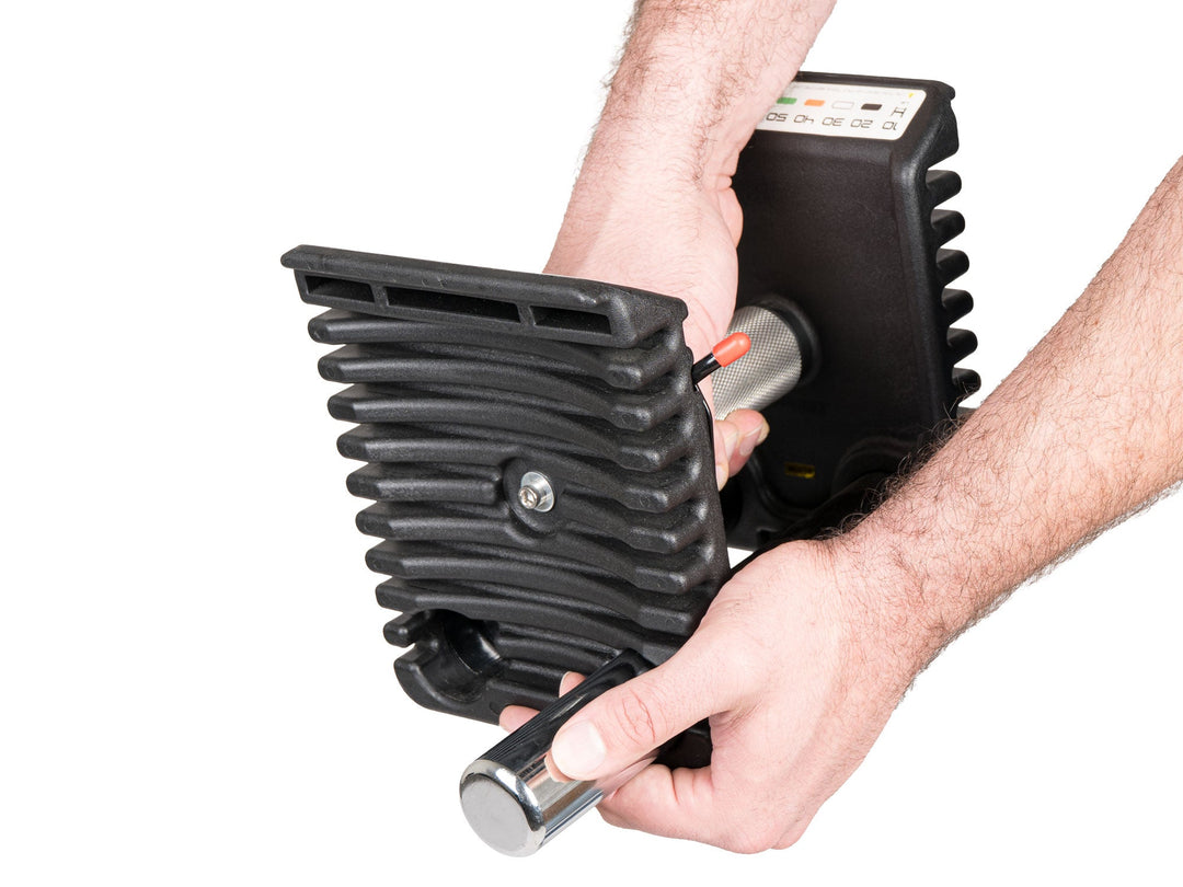 Hand removing a 2.5 lb micro weight from the handle of the PowerBlock Pro 100 EXP for half step weight changes