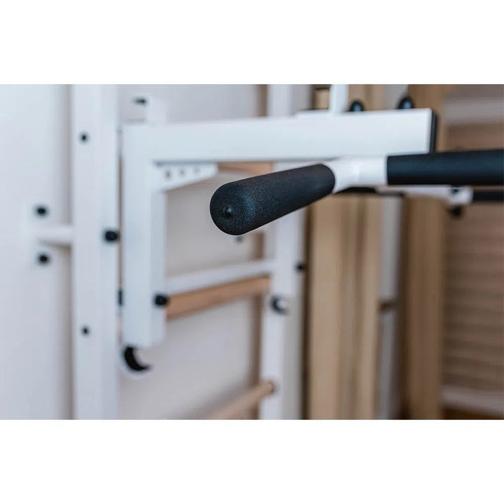 A close-up shows a black foam-covered handle on the BenchK Home Wall Bars w/ Flex Pull-Up Bar (731). The setup includes white metal exercise bars and wooden components, suggesting compliance with European safety standards.