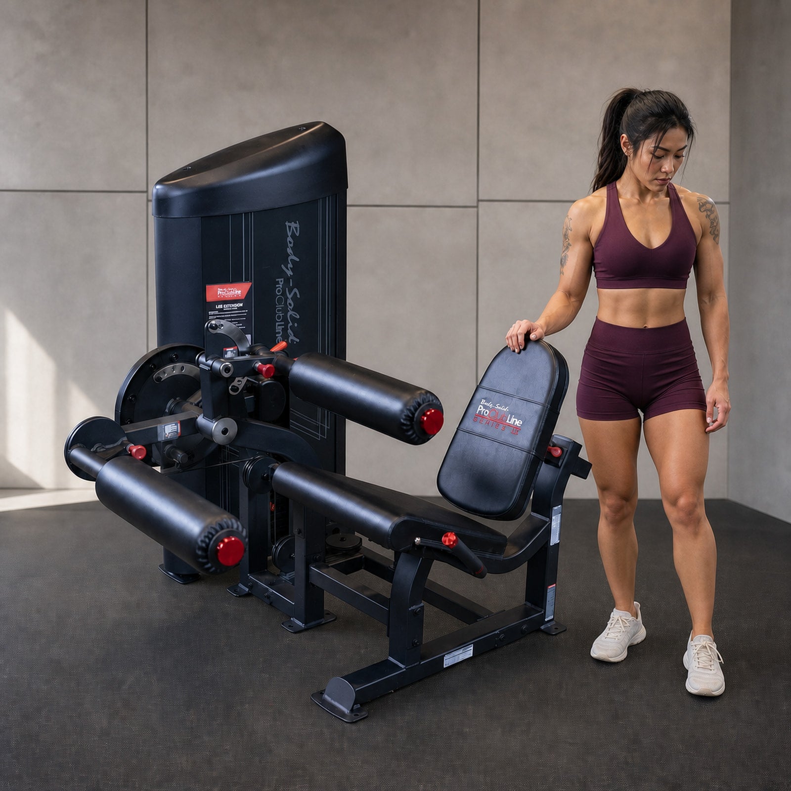 Body-Solid Pro ClubLine S2LECX leg curl and extension machine with athlete beside it for human scale