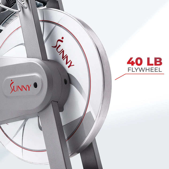 A close-up of the Sunny Health & Fitness Synergy Series Magnetic Indoor Cycling Exercise Bike showcases a sleek, modern design with a silver 40 LB flywheel accented in red, attached to a sturdy metal frame—ideal for those prioritizing both style and performance.