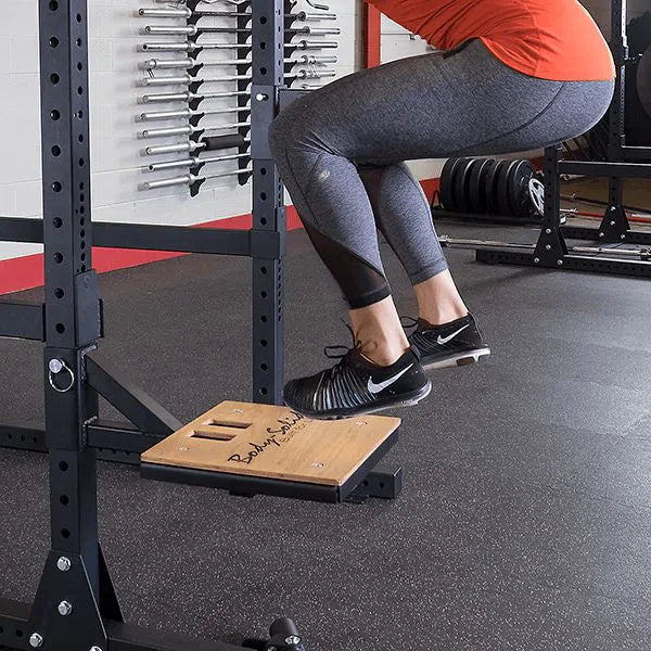 woman jumping on platform connected to power rack